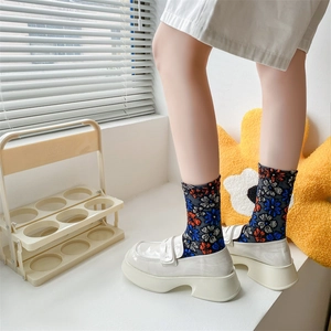 Detailed view of floral cotton socks styled with white platform loafers for women