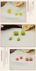 Macro detail of miniature resin fruit pendants featuring grapes and peach with metal hooks