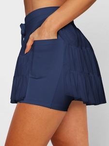 Detail of navy tennis skirt featuring mesh layers and functional built-in phone pocket