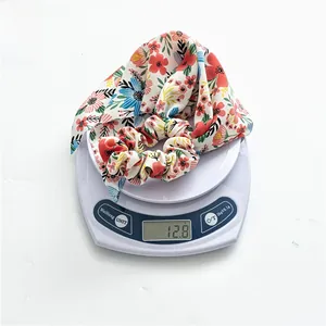 Floral chiffon scrunchie with long ribbons showing weight on a scale for quality check