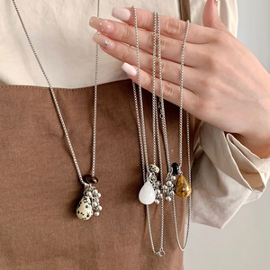 Detailed close-up of tiger eye stone grape cluster pendant on a silver metal chain