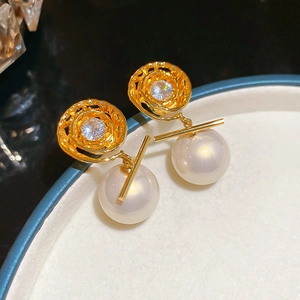 Macro detail of 14K gold plated vortex earring featuring a large pearl and zircon stone