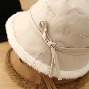 Close-up of beige wool bucket hat with herringbone texture and plush faux fur trim