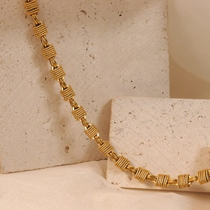 Thick gold-plated rope knot chain necklace with textured round links on stone