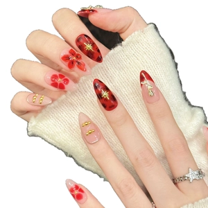 Handmade press-on nails with red flower motifs, amber textures, and golden bead accents