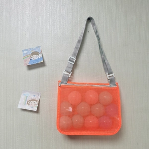 Detail of orange mesh beach bag for kids with gray adjustable strap and shell design