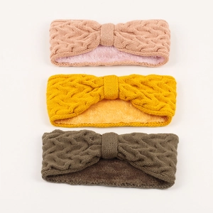 Detail of three cable knit headbands with soft fleece lining in pink, yellow and green