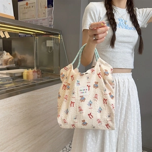 Detailed texture of seersucker tote bag featuring cute bear print and blue rope handles