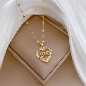 Detailed macro view of heart pendant with Love engraving and crystals on beige jewelry box