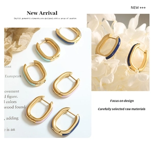 Detailed close-up of U-shaped enamel earrings in gold finish with pastel blue and pink tones