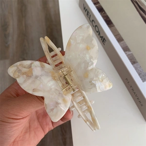 Detail of elegant acetate butterfly hair claw with iridescent mother-of-pearl texture