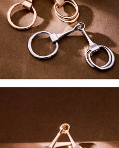 Detailed view of horsebit scarf rings in polished gold and silver metal finishes