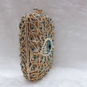 Macro detail of luxury crystal clutch bag with evil eye rhinestone pattern on metal frame