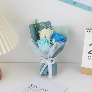 Close-up of handmade soap flower bouquet with white and blue roses in premium gift wrap