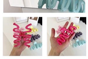 Close-up of wavy macaron hair claws showing glossy texture and various pastel colors
