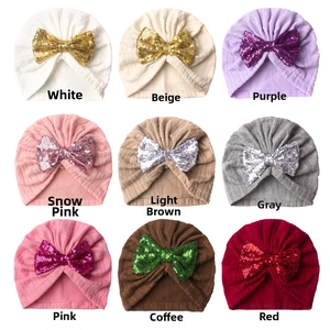 Detailed grid of baby turban hats in nine colors with sparkly sequin bows and knit texture