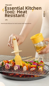 Macro shot of a yellow duck silicone oil brush applying oil to grilled skewers in the kitchen