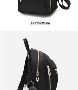 Detail view of black nylon backpack showing gold metal zippers and side perspective
