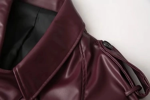 Close-up of deep red leather jacket collar with black buttons and premium stitching