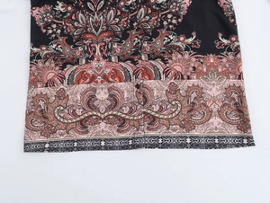 Detail of paisley print on ethnic style long sleeve blouse with buttons and hemline