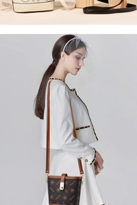Brown bucket bag with MOCKDE print shown on a model in a white suit for style reference