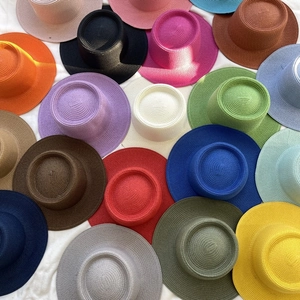 Flat lay of colorful summer straw hats in various vibrant shades for sun protection