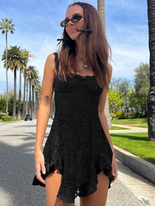 Détail d'une mini robe en dentelle noire à ourlet volanté dans un décor ensoleillé