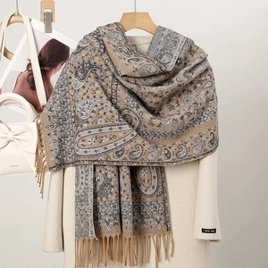 Close-up of winter scarf fringe detail with paisley floral patterns and hand made label