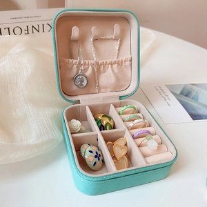 Close-up of portable jewelry box with necklace hooks and ring slots in mint green