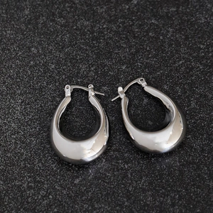 Detailed view of silver oval hoop earrings with high-polished metallic mirror finish