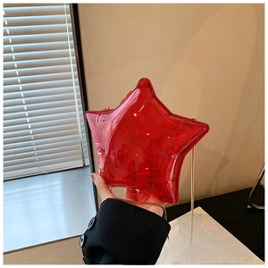 Detail of red transparent star-shaped acrylic bag with elegant gold metal chain strap