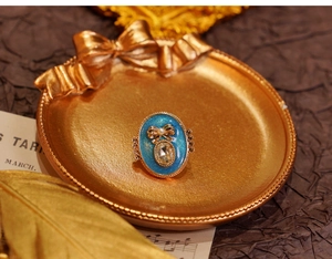 Detailed close-up of a vintage oval blue starburst ring with a small bow and pearl inlay