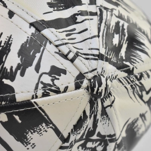 Macro shot of top button and dual stitching on a tie-dye graffiti baseball cap