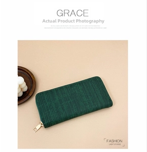 Detailed close-up of dark green striped leather wallet with a premium gold zipper fastener