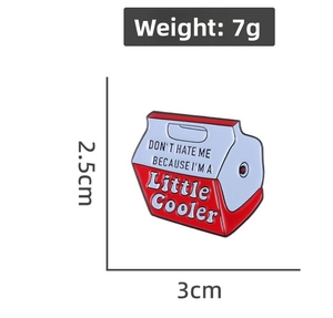 Detailed view of enamel cooler pin with text measuring three centimeters by two point five