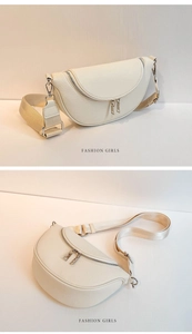 Detail view of cream leather crescent bag featuring pebble texture and silver zippers