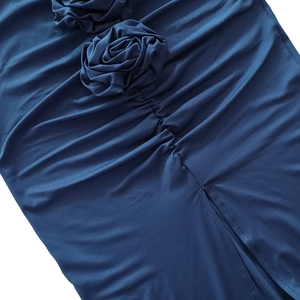 Close-up of dark blue skirt with ruched detail, 3D fabric flowers and hem split