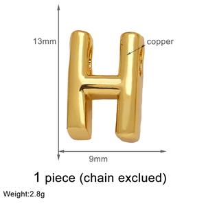 Close-up of golden letter H pendant made of copper, 13mm size, chain excluded