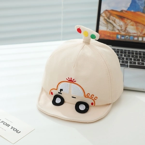 Gros plan d'une casquette beige pour bébé avec broderie de voiture et bord souple