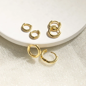 Three pairs of minimalist 18K gold plated hoop earrings in various sizes on white base