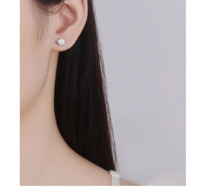 Detailed view of asymmetric S925 silver star and planet stud earrings on ear