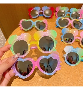 Detail of colorful cartoon sunglasses with character ears and decorative bows on frames
