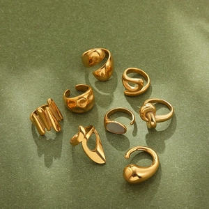 Macro detail of 18K gold-plated irregular knot and teardrop rings with white shell inlay