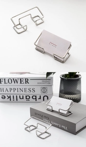 Macro shot of silver metal business card holder with geometric wire design for desk storage