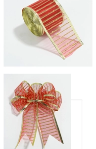 Detail of red and gold striped organza ribbon roll and a pre-made decorative holiday bow