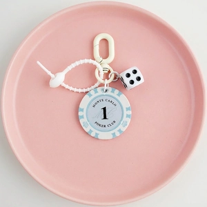 Detail of blue Monte Carlo poker chip and white dice on a silicone beaded keychain