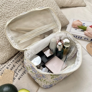 Detail view of floral makeup bag featuring internal mesh pocket and large capacity storage