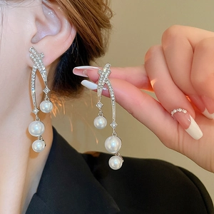 Vue détaillée de boucles d'oreilles pendantes argentées avec perles et zircons étincelants