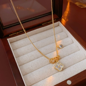 Dettaglio di una collana con ciondolo a fiore placcato oro 18k in una scatola di legno