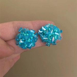 Detailed view of handmade blue beaded flower earrings with faceted crystal details